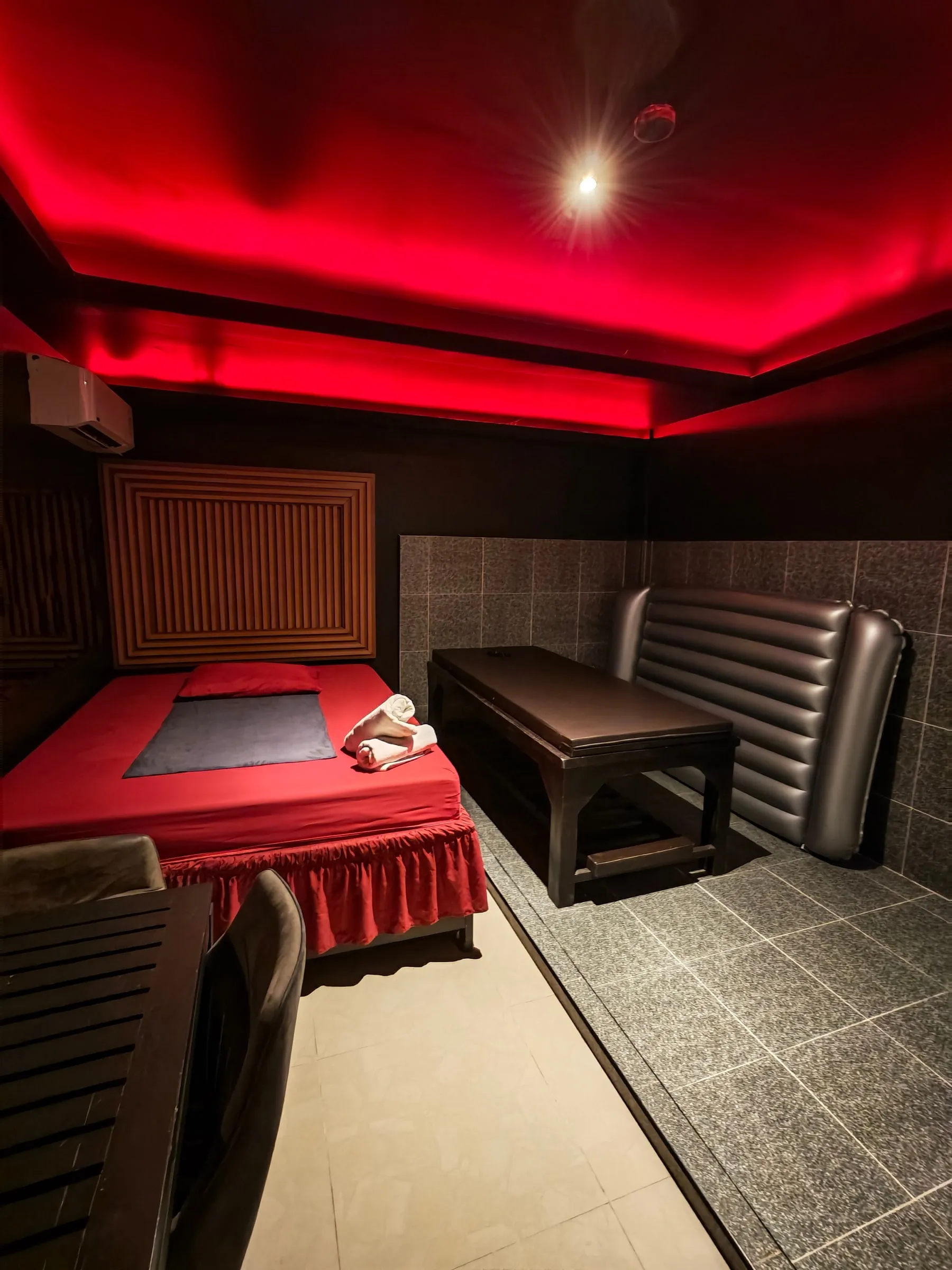 Amor 888のヌルマッサージのお部屋。ベッドとマッサージテーブル、タイルの壁に立てかけた銀色のエアマット
